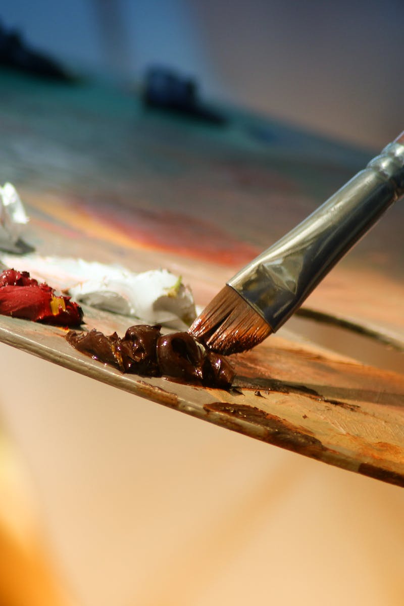 Vibrant artist palette with paint and brush creating colorful artwork.